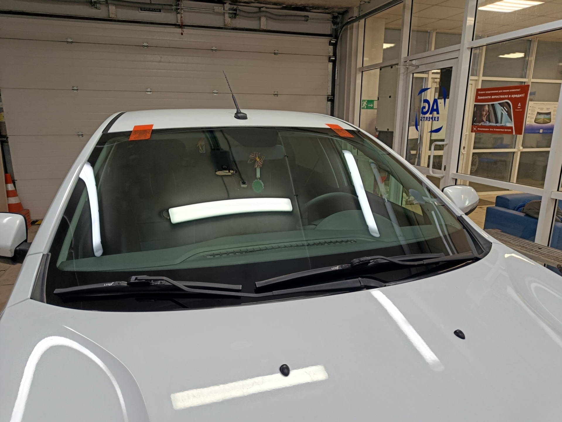 В общем, машина стояла на улице весь ноябрь. Приехал с командировки и утром завёл, а сам пошел домой пить чай пока она грелась. Через пол часа выхожу и вижу, что по всей длине лобовой появилась трещина от небольшого скола — поймал камушек летом, когда ехал на море.

Трещина на всю длину. Стекло SISECAM
Вроде особо и не мешается, но напрягало, что находится на уровне глаз. Так покатался где-то месяц и решил позвонить нескольким фирмам, так сказать узнать цены рынка. Первой фирмой оказалась AG Experts. Цену за стандартное стекло Бор с небольшим затемнением и зелёным оттенком озвучили 7800 рублей. Установка бесплатная. После этого даже звонить не стал другим фирмам, а сразу записался на удобную дату — цена меня устроила. Во время разговора уточнил ещё раз нужную модель стекла с евро-кодом 4592AGS и переспросил точно будет оригинальный Бор, а не какой-то кооператив… Ответили, что будет 100% Бор, который сейчас ставят на конвейер, надо только выбрать вариант его исполнения: с датчиками или без, и т.п. Попросили в день установки заранее заехать на мойку.

А вот и мойка. Прайс — космос для Уфы, одна фаза 600 рублей 🙂 и это только наружка…
После мойки заехал в соседний бокс, где уже весёлые ребята за несколько минут разобрали жабо и сняли старое лобовое.

Старое заводское стекло SISECAM
На фото видно тот самый скол, с которого всё пошло по швам…

Парни срезали лишний герметик и обезжирили поверхность
Видно, что на заводе особо не заморачиваются и наносят герметик так себе. Теперь понятно, почему у некоторых владельцев вода в салоне: на фото можно найти уязвимые места.

Новое стекло установлено. Теперь у нас Бор.
Пол часа и готово!

Стекло ветровое Бор 8450007323 E22 43R-000122 Lamisafe
После того как приклеили, я ещё часик погулял в ближайшем ТЦ пока схватится герметик, вернулся и успел пообщаться с мастерами. Прошло 2 часа и я не спеша поехал домой.

P.s. Парни сказали, что стекла AGS и Бор делают в одном заводе, чему я был удивлён.
