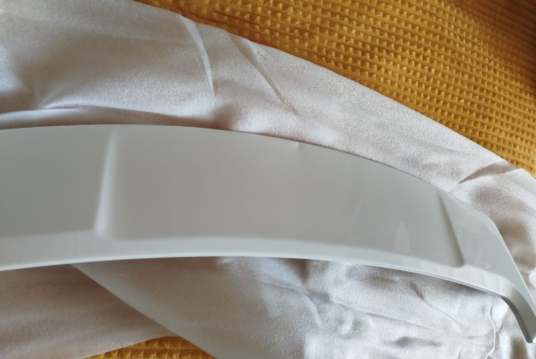 Спойлер — один из немногих элементов стайлинга для Outlander, который вызывает минимум споров — разумеется, с ним лучше, чем без него :)


Со спойлером теперь
Итак, заказал на Али сразу крашеный… По прикидкам некрашеный+покраска (зато точно в цвет) получалась примерно в 15Круб. Окрашеный сразу в белый — 4,3Круб. Решил рискнуть.

Пришел спойлер в транспортную компанию упакованный в пузырчатую пленку основательно, как мумия :)
И, тем не менее — сурпрыз! Заметный залом на внешнем ребре :(


Ну как так?
Ну в той 10-сантиметровой толщины обертке вряд ли так могло получиться, скорее всего сразу таким положили.
В-общем, подал спор (изначально подумал, что оспоренный деньги отдам мастерам, чтобы шпатлевали и красили). Отспорил 1,8Круб. То есть спойлер с дефектом обошелся в 2,5Круб.


По цвету — очень хорошее попадание, разве что на спойлере есть примесь блестящая (наверное, это Polar White или как его там). Но с завода бампера от кузова отличаются существенно сильнее :)
Уже начал у знакомых спрашивать, кто занимается такими работами, никто не признавался… повертел-покрутил в руках и решил кое-что попробовать :)

Сделал технологическое отверстие на внутренней стороне, обмотал изолентой наконечник длинной отвертки, нагрел спойлер в теплой воде, арендовал у жены фен и поставил его на минимальный нагрев.
Ну и изнутри минут за 30 осторожненько выровнял дефект.


Технологическое отверстие и инструмент
Пару недель спойлер отлежался на балконе (проверил, не сработает ли эффект памяти у пластика, когда остынет). Дефект проявился прям минимально (и то, это я знал, куда смотреть). Еще минут 10 повторил процедуру поддавливания и нагрева — и вуаля! Результат отличный.


Живьем вообще место дефекта не найдешь
Следующим квестом оказалось прикрепление.
Дальнейший текст скорее всего будет более интересен ростовчанам…

Беглый поиск стекольного герметика и праймера показал, что это добро обойдется в пару тысяч, не меньше. И потом почти весь герметик все равно на выброс…
Заехал в пару мест, где устанавливают стекла. В одном (федеральная сетка, АвтоТрейд) сразу сказали, что у них нет такой услуги в прайсе, а "внепрайсовые работы" караются штрафом и вплоть до увольнения. Но общались вежливо.

В другом (с довольно живыми социальными сетями, вроде как позиционирующие себя положительно, Автостекла на Вавилова) — просто вышел чувак, ни здрасте, ни досвидания, просто сказал "нет, я это делать не буду" и развернулся. Резкий контраст с социальными сетями. Неприятный осадочек :)

Уже подумал — ну всё, придется самому материалы покупать и звать кого-нибудь на помощь для ровной установки. Но решил заглянуть к еще одним установщикам автостекол. Оказалось, неподалеку есть AG Experts. Ребята красавчики — и пообщались вежливо, и один парень вышел посмотрел-пощупал спойлер. Согласились сделать. Подошли прям очень профессионально — все обезжирили, нанесли праймер, погрели феном и спойлер и крышку багажника, нанесли герметик, приклеили спойлер. И стоимость услуги нормальная — 1,5Круб.


Кепка
В-общем, теперь Белый Бумбр со спойлером.
Считаю, что он делает внешний вид аута существенно гармоничнее. Плюс стоимость доработки получилась ну очень приятной.